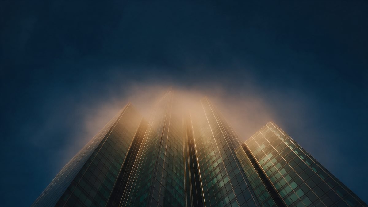 A cluster of modern glass towers seen from below at golden hour